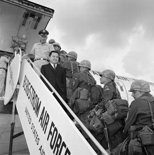 Sen. Daniel Inouye of Hawaii (dark suit) watches troops of the 2nd Armored Division, Fort Hood, Texas board a C135 jet transport plane on Oct. 23, 1963 at Bergstrom Air Force Base, Austin, Texas for a flight to Germany. The senator, a member of the Senate Armed Services Committee accompanied them on their flight, a part of exercise big lift. Col. Frank R. Walsh, 340th group commander, stationed at Bergstrom AFB stands behind Sen. Inouye. (AP Photo)