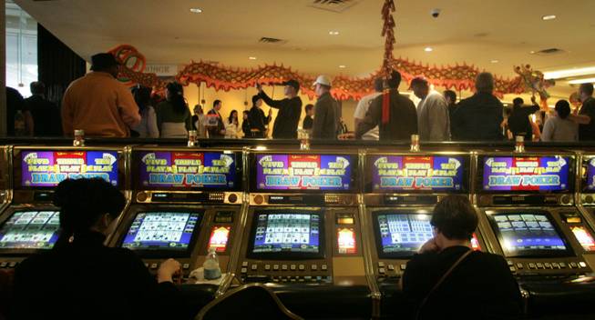 Gamblers keep playing their slots while members of the Lohan School of Shaolin perform a dragon dance  Las Vegas Hilton casino Saturday.