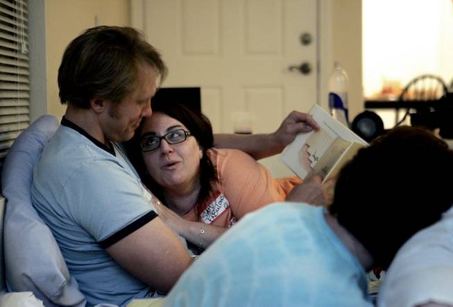 Reid Mihalko, left, co-creator of the Cuddle Party, reads "Hug Time" by Patrick McDonnell to a cuddler. He flew in from New York for the party and laid down ground rules, including that guests must ask for permission before touching anyone.