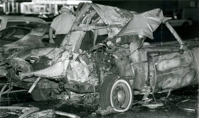 Investigators examine the area surrounding the twisted remnants of Frank "Lefty" Rosenthal's car after a bomb destroyed the vehicle on Oct. 4, 1982. A metal plate directly underneath the driver's seat of the Cadillac diverted the explosion away from Rosenthal, saving his life.