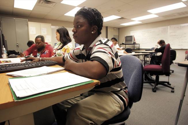 Angel Lee works on an English class book report Wednesday at Desert Rose Adult High School. Lee returned to school after dropping out.