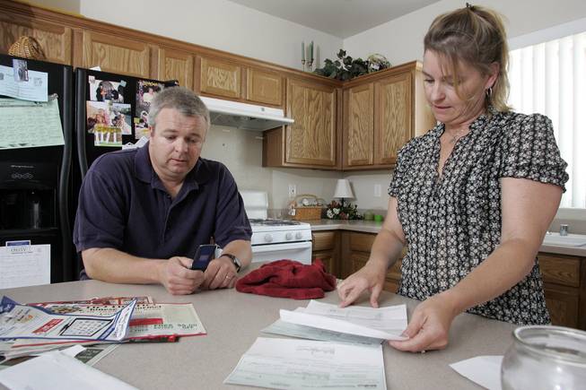 Peggy Montgomery looks over a deposit refund check and documents from a property management company on her last rental home while her husband, Dan, tries to call the management office. The Montgomerys expected $1,500 but received $850 after deductions. After they moved from the home they lived in before that one, they got nothing back. And moving expenses have been about $1,000 each time, they say.