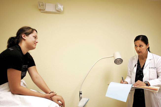 Jameson talks to patient Brandi Johnson, 19, during a visit to Jameson's office on Friday. Jameson says when she was a child being raised by a single mother, a family doctor would "graciously take care of us for nothing."