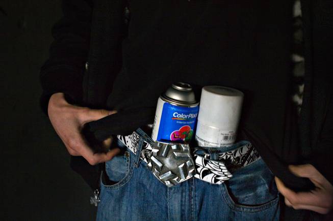 Stashing cans of paint, Ruckoh packs up to walk more than a half mile into a storm drain to paint a mural that will take more than six hours to finish.