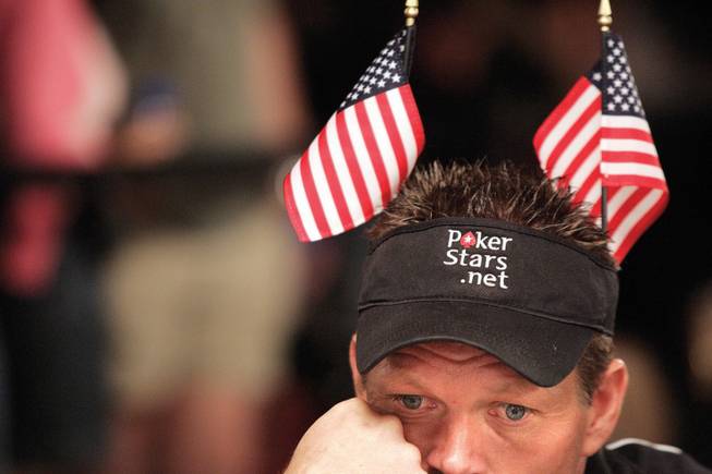 Noble Simpson of Jena, La., wears a pair of American flags as he mulls a hand. More than 1,000 flags from countries around the world were passed out at the beginning of the day.