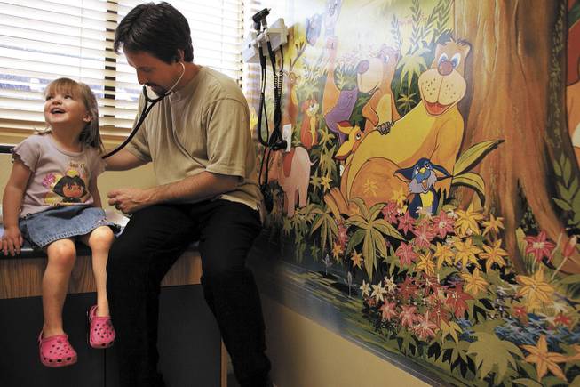 Dr. James McGhee examines 3-year-old Zoey Lincoln during a checkup at his Henderson office Thursday. Because some insurance companies may not cover the entire cost of chickenpox vaccinations, some doctors are wary of putting up the money to buy the vaccines.