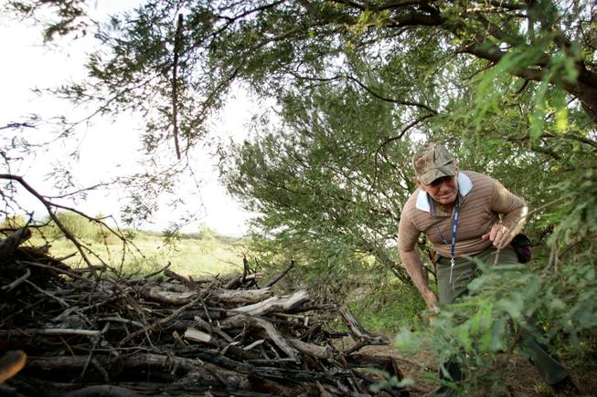 Minuteman James Bulman of Green Valley, Ariz., scans brush during his first "muster," held Friday on a private ranch near Amado, Ariz. "This is my first time out with the Minutemen," Bulman said, "so I'm learning what's going on."