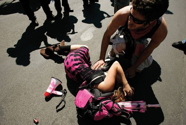 Alicia Forrest, right, is consoled after being hit in the chest and knocked over by a Denver police officer during demonstrations at Civic Center Park on Tuesday. Forrest was arrested shortly afterward while talking to a journalist about the incident.