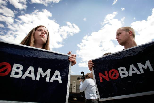 
Beck Gudmundson, left, of Salt Lake City and Mark Streeter of Bountiful, Utah, hold up political signs Tuesday in Denver.