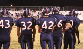 Members of the Coronado High School football team watch Friday as their teammates continue the assault against the squad from Clark High School.