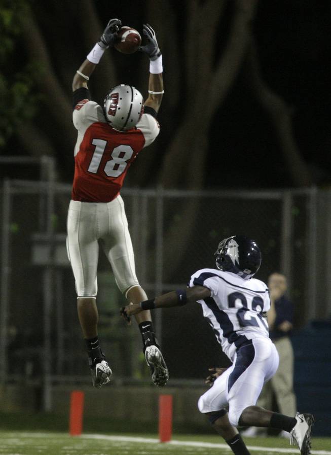 UNLV's Phillip Payne makes a catch over UNR's Joe Easter during the Rebels' game against the Wolf Pack at Sam Boyd Stadium.