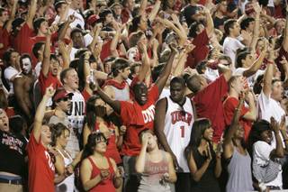UNLV fans cheer as their team takes the field against UNR at Sam Boyd Stadium.