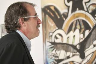 During Henderson's Third Thursday Arts Walk, conceptual artist and librarian Steven Baskin studies the work of artist Sean Russell while visiting The Water Street Gallery.