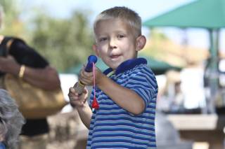 Four-year-old Ben Wilson fires his new popper gun he bought at Art in the Park.