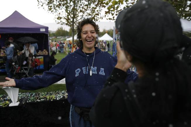 Monse Sanchez is photographed by her sister, Nuria, after snow flurries began to fall Saturday at The Gardens Park in Summerlin.