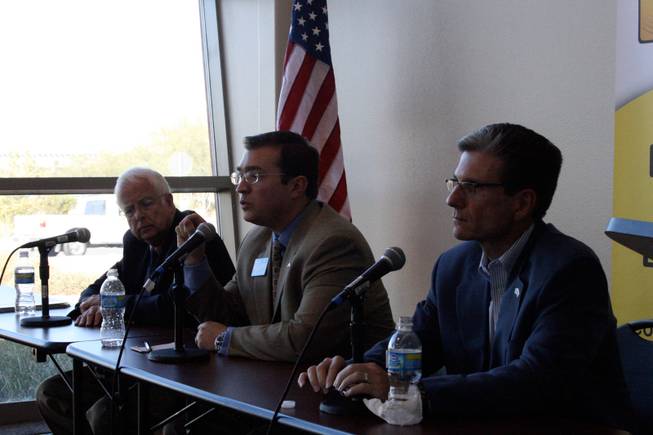 Lynn Stewart, left, and Joe Heck, right, listen as Sean Fellows speaks at a candidate forum Monday at the Paseo Verde Library.