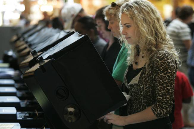 First-time voter Kirsten Garlock joins hundreds of others as she casts her ballot Saturday, the first day of early voting, at Galleria Mall in Henderson. Many polling locations across the state had heavy turnout. 