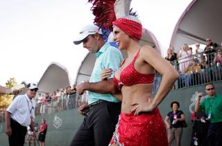 Marc Turnesa, who won the tournament with a 25-under-par score, is escorted by Jennifer Gagliano, right, to receive his trophy after the final round of the Justin Timberlake Shriners Hospitals for Children Open at TPC Summerlin on Sunday.