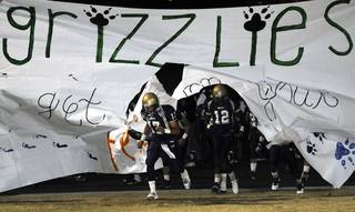 Alex Quintero (17) and Anton Stallworth (12) lead the Grizzlies onto the field before the start of Friday's home game against Bonanza.