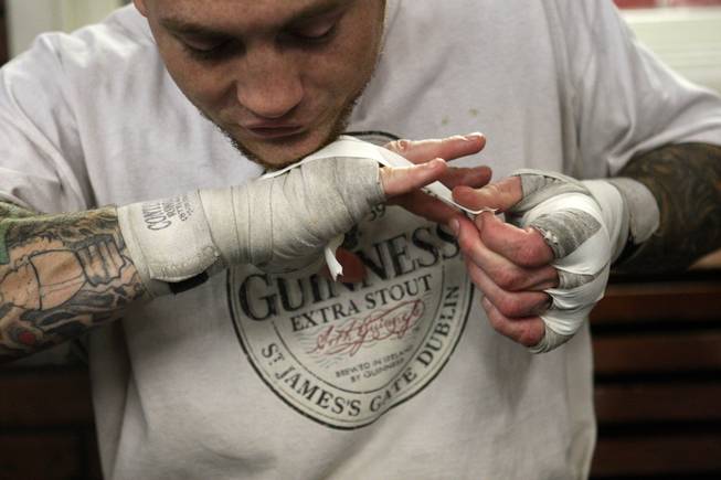 Super welterweight boxer Matt Vanda of St. Paul, Minn. uses his chin to hold down tape as he gets ready for a workout at Top Rank Gym in Las Vegas. Vanda, who has more than 100 tattoos "that all run together," says his latest ink will feature a scorpion for his soon-to-be-born daughter, Vivianna, a Scorpio.