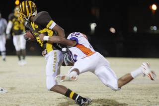 Bishop Gorman wide receiver Victor Belen brings down Bonanza running back Delano Helmuth at Thursday's football game at Bonanza High School.