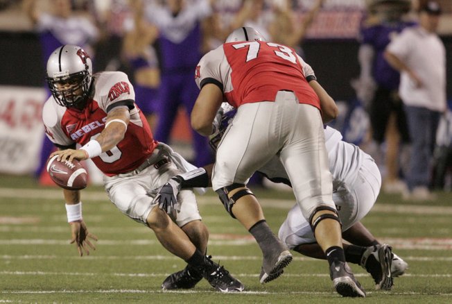 UNLV quarterback Mike Clausen trips over himself before being dropped for a loss during the second half of the game against TCU on Saturday.