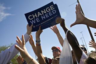 Campaign signs are handed out at an Obama rally where Michelle Obama spoke on the Cheyenne campus of the College of Southern Nevada in North Las Vegas on Monday.