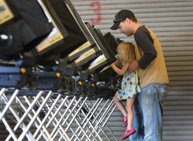 Wendy Davison, 2, helps her father Jeremy Davison cast his ballot at Fire Station #3 in Henderson
