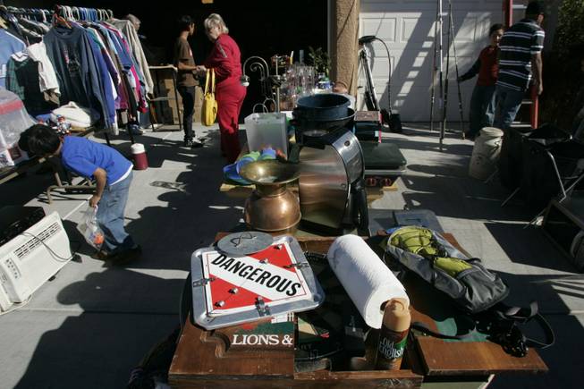A curious young shopper examines one of the wide variety of items available for purchase Saturday at Rosemary Montour's garage sale.