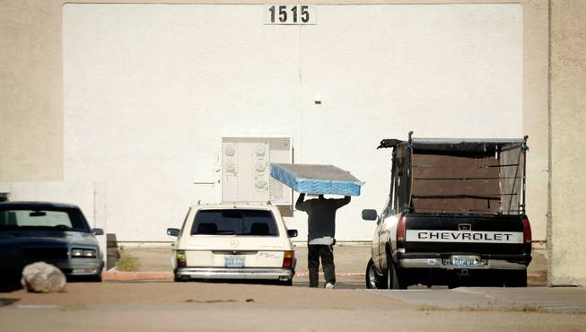A man carries a mattress to the dumpster inside Buena Vista Springs.