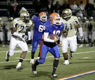 Bishop Gorman quarterback Joe Huber takes it up field against the Cheyenne defense.