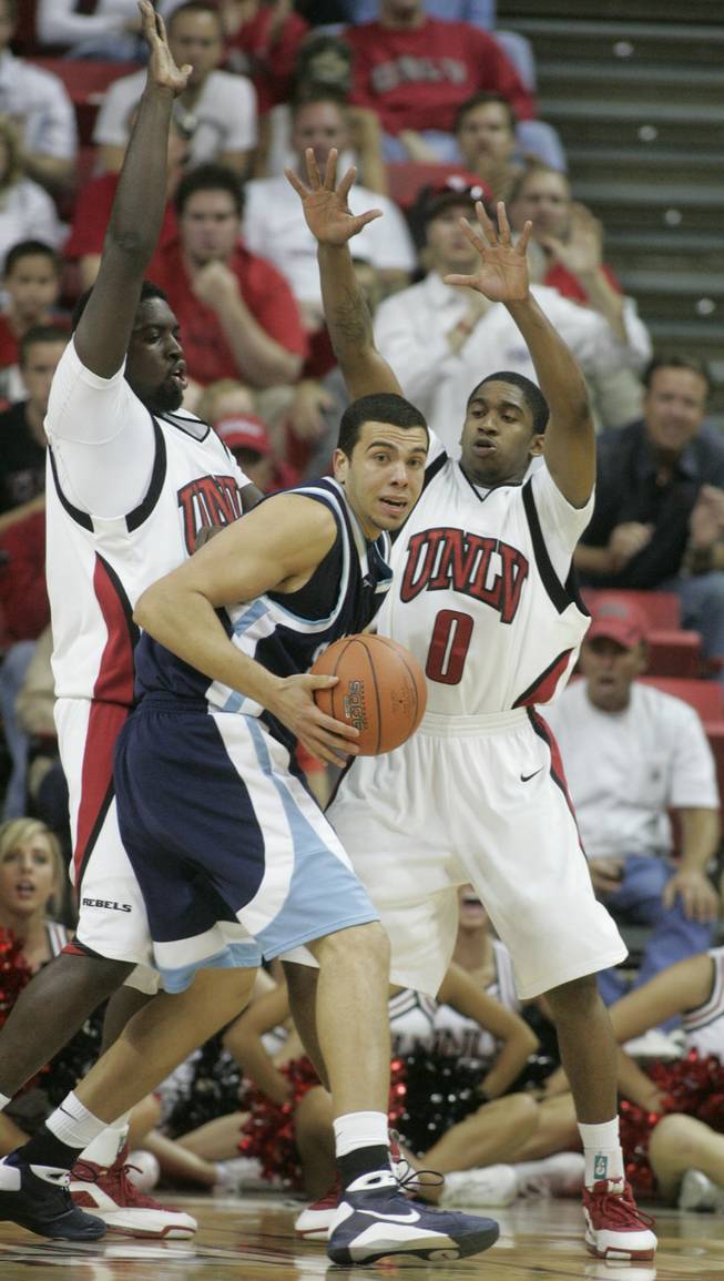 UNLV forward Brice Massamba, left, and guard Oscar Bellfield pressure San Diego forward Roberto Mafra during the second half on Nov. 15 at the Thomas & Mack Center.  UNLV won 65-60. 