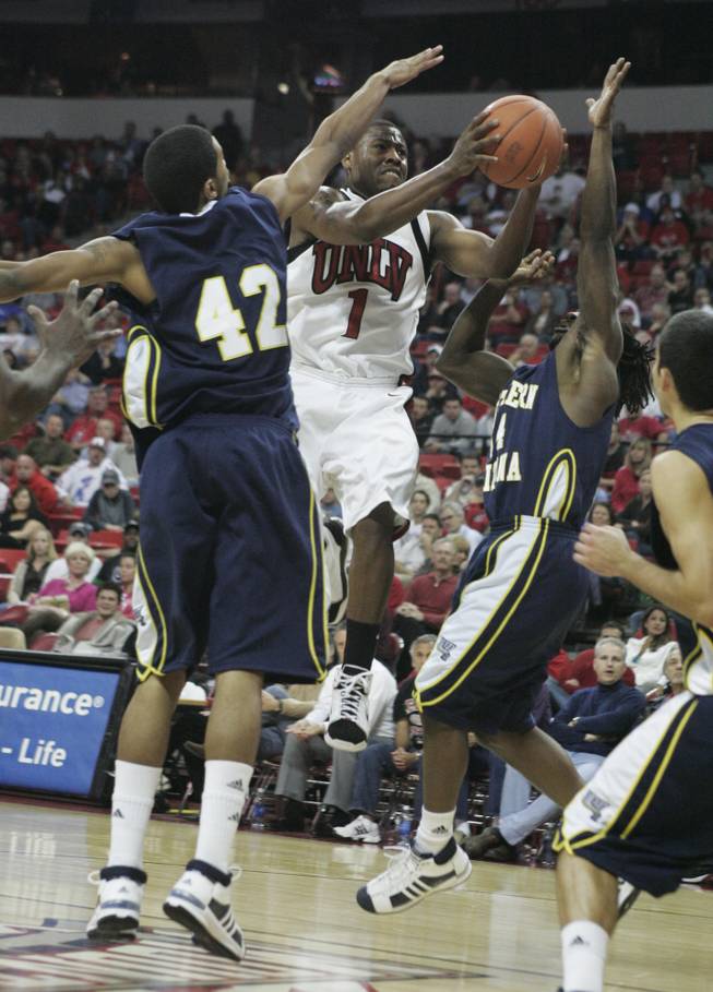 UNLV guard Wink Adams drives past Northern Arizona's Josh Lepley, left, and Jermaine Calvin during the second half of their game Thursday. Adams finished with a game high 18 points as UNLV won the game 87-71 to improve to 3-0.
