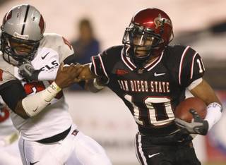 San Diego State's Davion Mauldin (10) fights for yardage against UNLV's Deante Purvis, left, on a kickoff return during the first quarter.