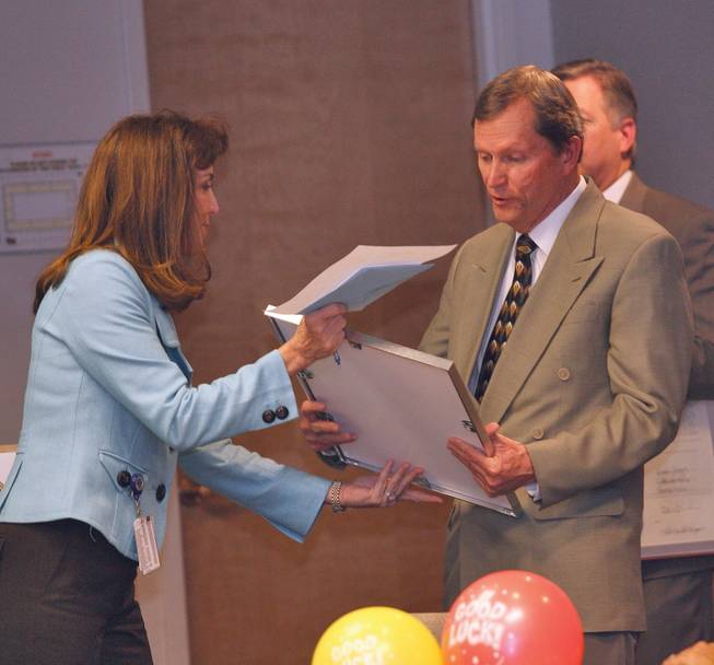 Clark County Manager Virginia Valentine, left, presents Clark County Commissioner Bruce L. Woodbury with a plaque acknowledging his decades of service on the commission during a farewell celebration at the Clark County Government Center on Dec. 17. His current term of office expires the first Monday in January 2009.