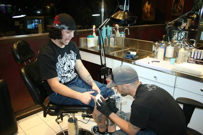 <p>11:40 p.m.: Hart and Huntington tattoo artist Josh Sutcliffe has a coworker add some color to his knee cap on New Year's Eve.</p>
<p>The 24-year-old already had 17 tattoos but he figured one more wouldn't hurt. He chose the logo of his favorite rock band, the Red Hot Chili Peppers, as the design.</p>
<p>While the motif was a contrast from the mostly Asian-inspired ink Sutcliffe already had (he has a thing for koi fish, apparently) he thought the design was appropriate.</p>
<p>"That's my favorite band," he said. "I'm super influenced by them."</p>