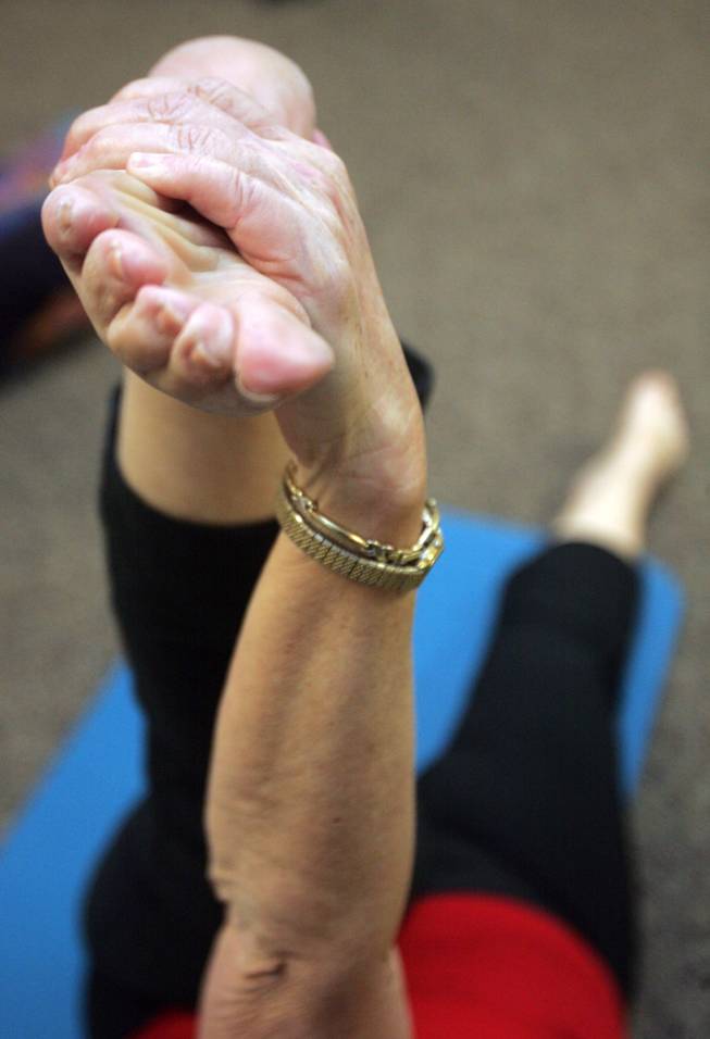 Iris Corley stretches out before a special holiday yoga class at the Paseo Verde Library.