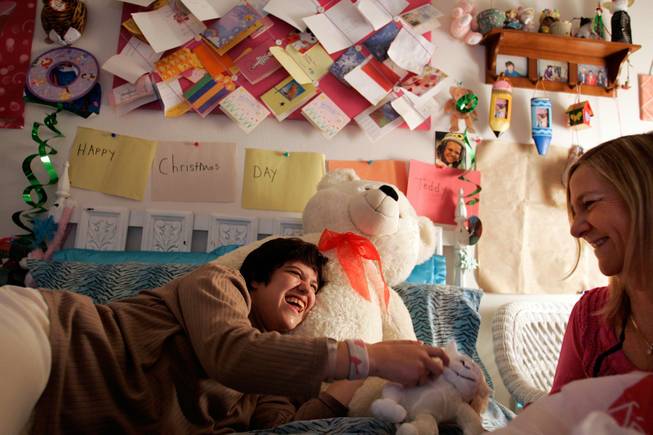 Christina Sablan, 26, and her mother Julie Olvera talk in Sablan's bedroom inside her apartment in Las Vegas on Wednesday, Dec. 31, 2008. Sablan, who had a viral infection in her brain as a baby and brain damage as a result, had little success in 12 group homes and on multiple medications. A year and a half ago she was given her own apartment, with supervised staff, and has flourished in that environment, says her mother, who communicated with her daughter through sign language and written notes.  