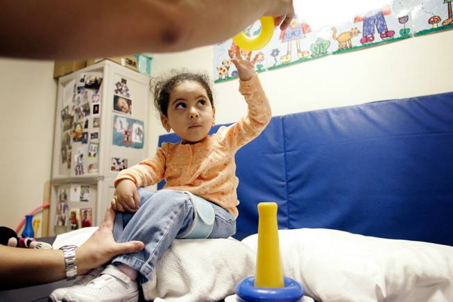 Physical therapist Edwin Suarez works with Medicaid patient Maliylah Silva, who has been diagnosed with spinal muscular atrophy, at his office in Las Vegas Tuesday, Dec. 23, 2008. Silva needs regular therapy sessions for her degenerative condition, and Suarez fears he cannot continue to see patients with Medicaid insurance because the Medicaid reimbursement rate was reduced in the last round of budget cuts.  