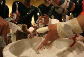 The Brown's Gymnastics' team chalk up before competing in the Lady Luck Invitational at the Southpoint Casino Saturday.
