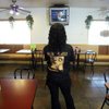 
Before opening M&M Chicken-N-Waffles for the day Tuesday, waitress Iesha Hall watches President Barack Obama speak at his inauguration in Washington. 