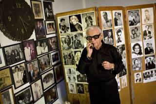 Surrounded by personalized pictures of musicians and celebrities he has played with and for, Sasha Semenoff takes a phone call at home before heading to work on Sunday night.