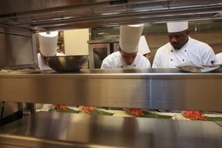 Chefs work together to prepare food behind the line in the main kitchen during a preview of restaurants at M Resort.