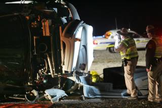 Department of Public Safety officers take photos after a fatal tour bus accident Jan. 30, 2009, on U.S. 93 near Dolan Springs, Ariz. Police said at least seven people died. The bus, reportedly carrying a Chinese tour group, was northbound toward Las Vegas before the crash.