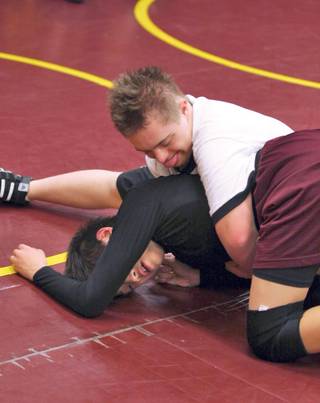 Eighth grader Billy Wolfbrandt, in white, practices some wrestling moves on teammate Danny Chung during practice at Faith Lutheran Middle School.