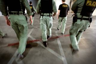Members of Metro Police's vice unit walk from the parking garage to the service elevators of a Las Vegas Boulevard condo tower to search the condominium of a suspected pimp Tuesday. 