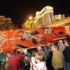 Joey Logano's car hauler passes by fans during a parade of NASCAR haulers on the Las Vegas Strip on Thursday, Feb. 25, 2010.