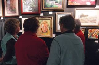 From left to right, Marian Griffin, Barbara Connell, Connie Romero, and Kitty Rivers admire Connell's painting of her granddaughter at a reception for the City Lights Gallery's first juried fine art show on at the Liberace Museum showroom.