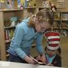 Maddy Kossman, 8, helps her 2-year-old sister, Milla, right, make a "Cat in the Hat" craft during the 2009 grand opening of Henderson Libraries' branch inside the Galleria at Sunset Mall.