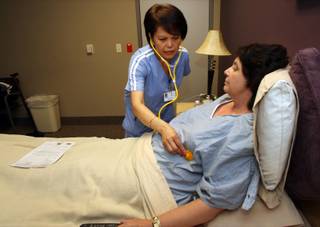 Nurse Terrie Young, originally from the Philippines, checks on 